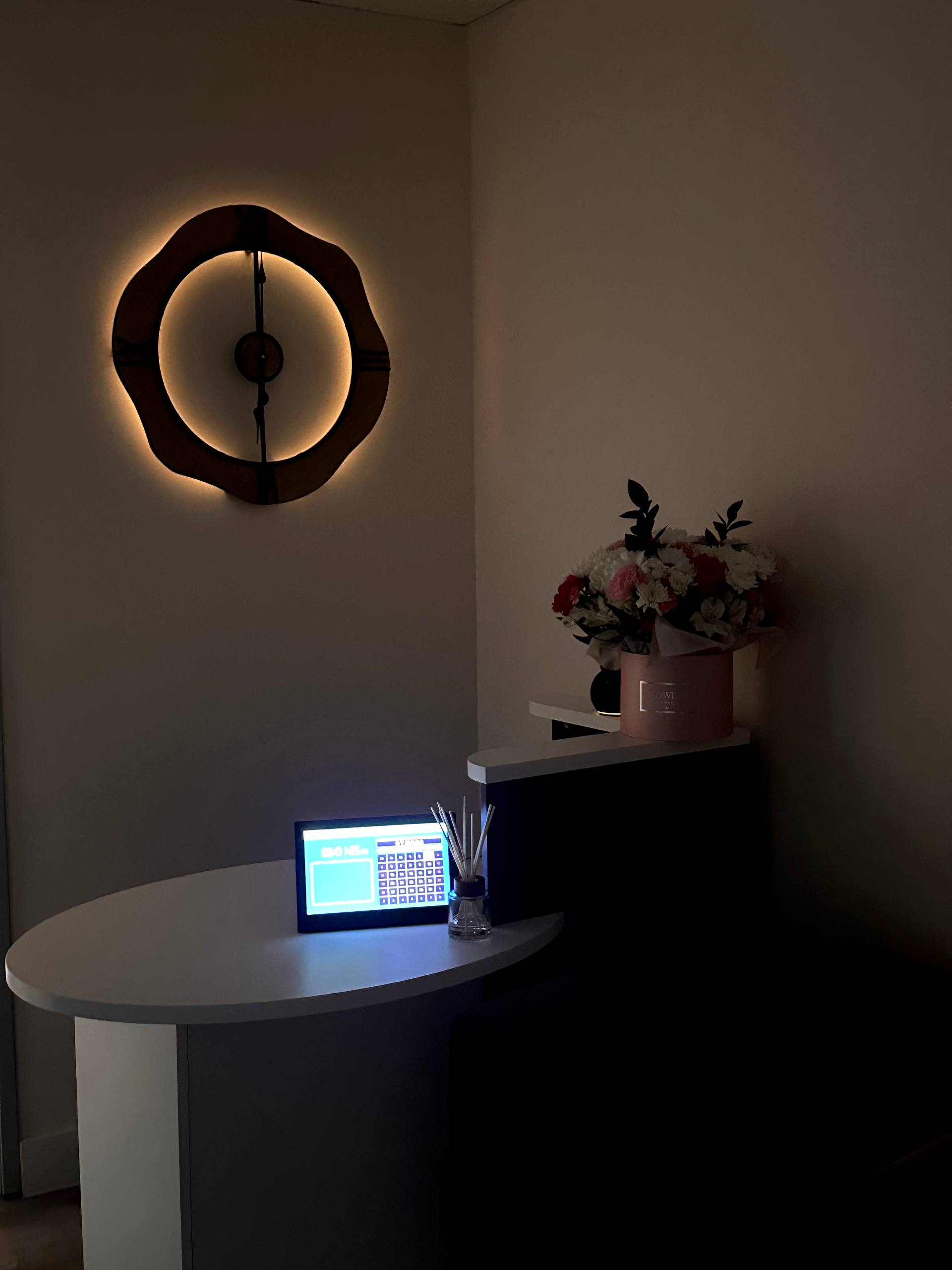 Sculpt & Glow front desk with booking tablet and fresh flower arrangement