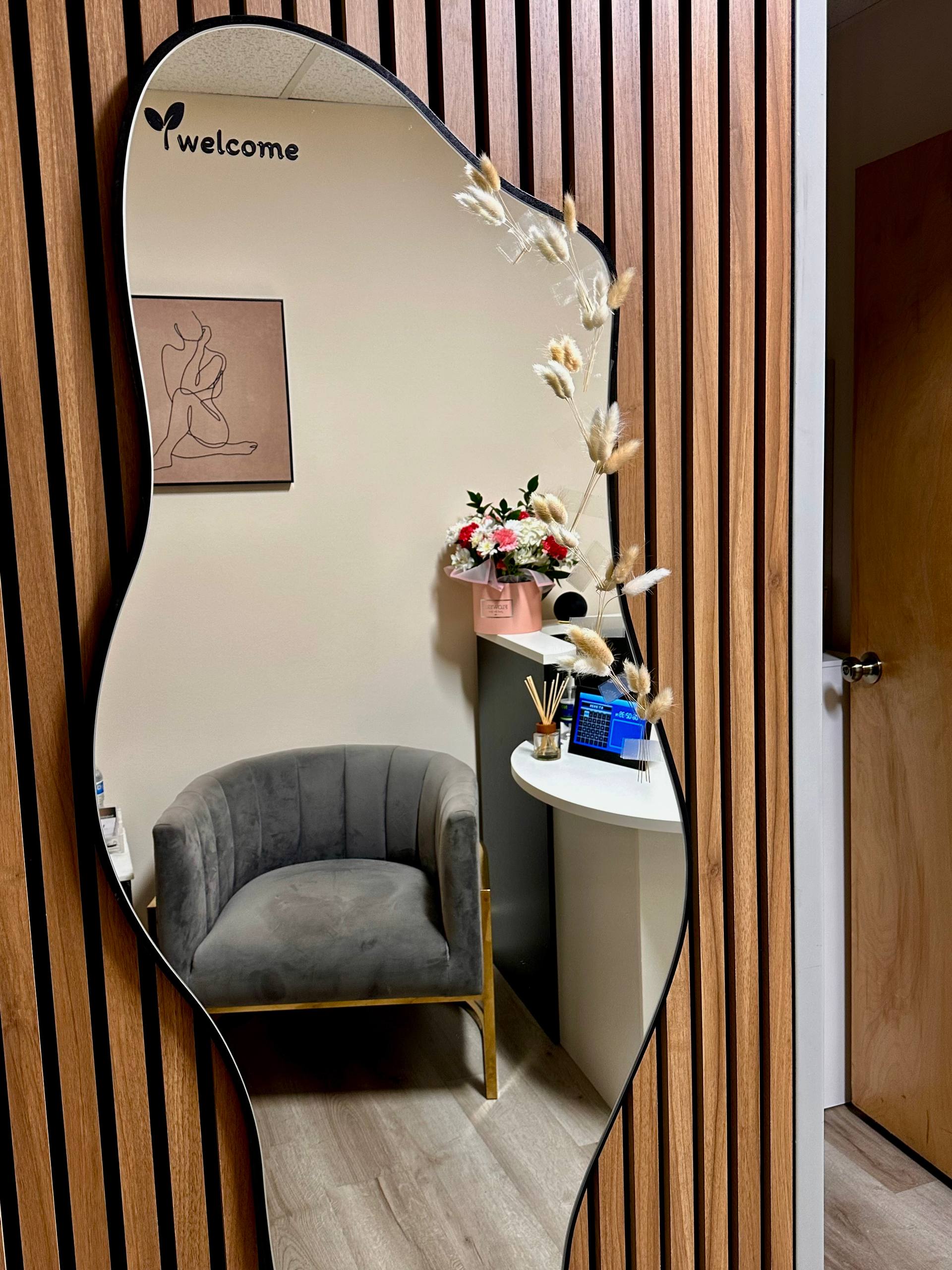 Sculpt & Glow waiting area with velvet chair, fresh flowers and welcoming reception nook